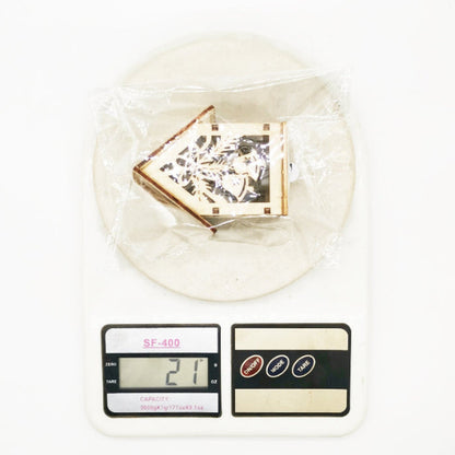 Gewicht 21 g – houten kersthuisje in verpakking op weegschaal